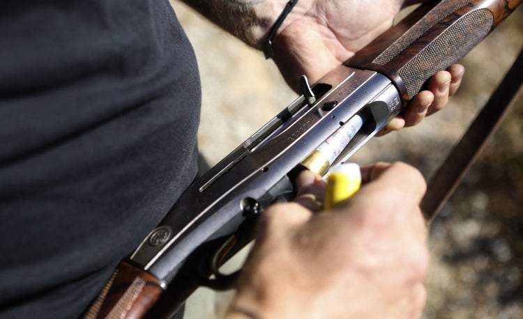 white man loading hunting rifle