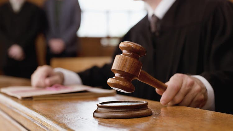 Judge holding gavel in courtroom