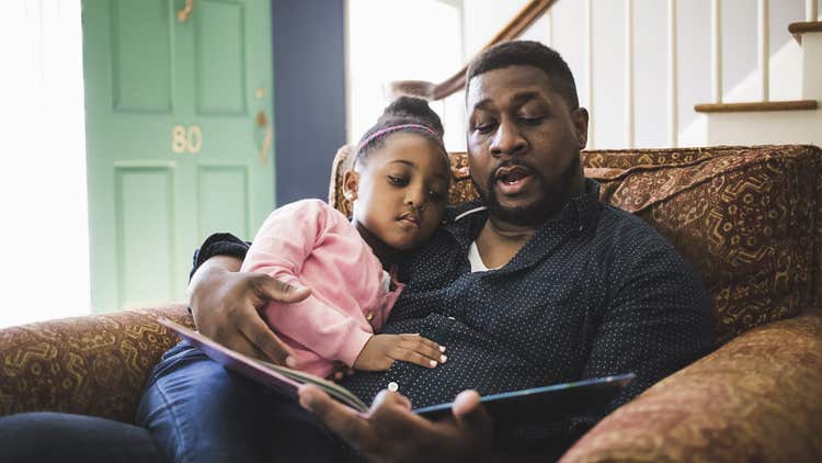 Father and daughter reading book