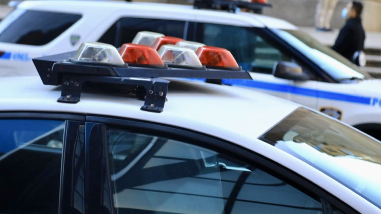 Police vehicles with overhead strobe lights at a crime scene